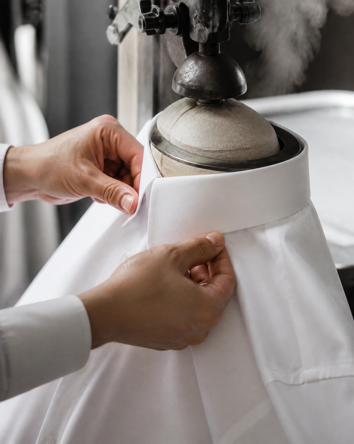 Steam pressing the collar of a crisp white business shirt